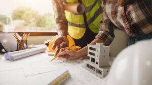 twee mensen die iets aanduiden op het ontwerp van een nieuwbouwproject
