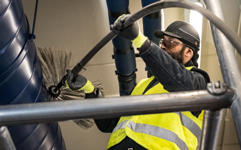 een expert die bezig is met het reinigen/onderhouden van industriële proces- en ventilatiekanalen